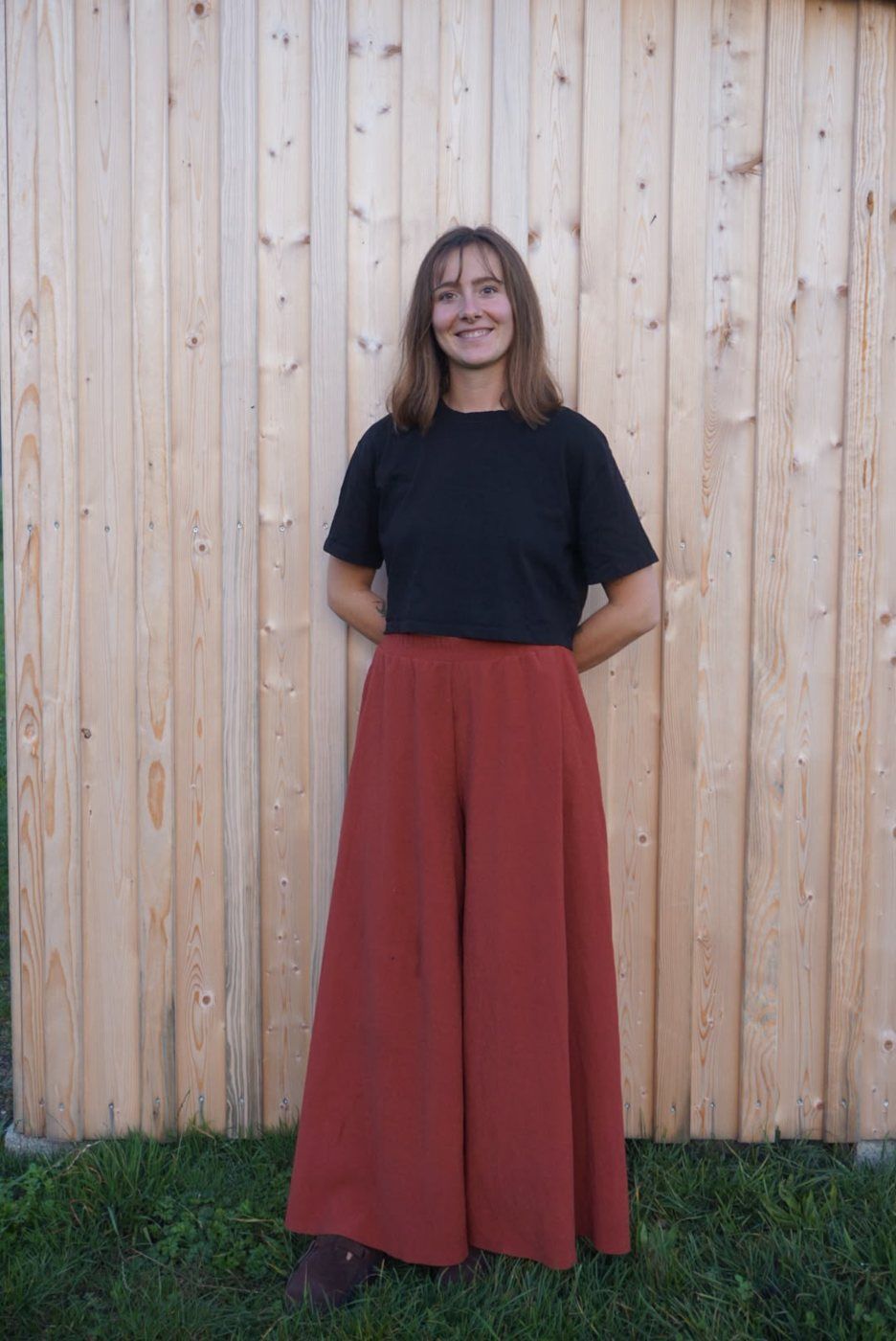 Johanna Bernrieder in ganzer Figur vor einer hellen Holzwand
